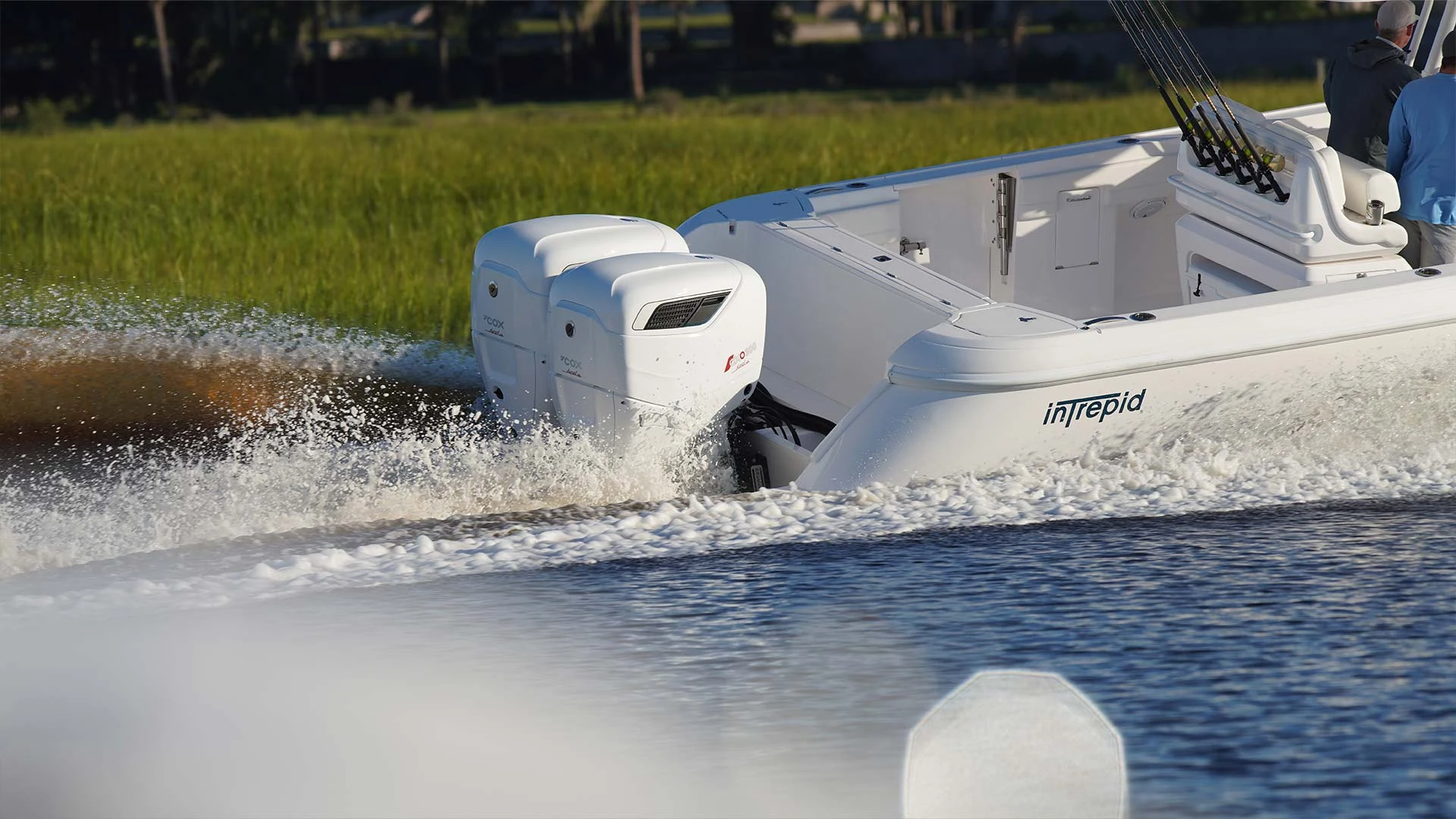 Cox outboards powering a boat through spray