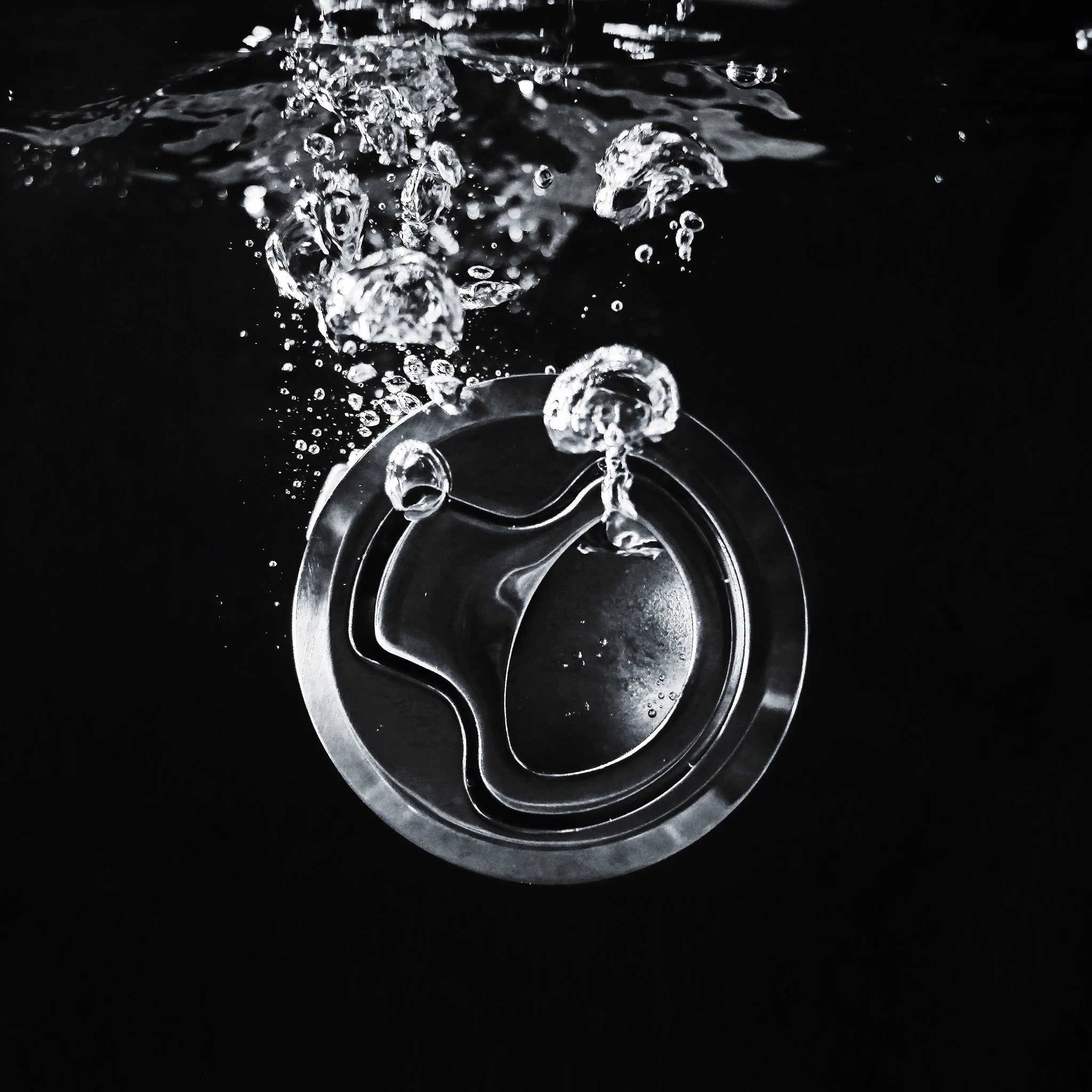 Polished Gemlux latch among bubbles against black
