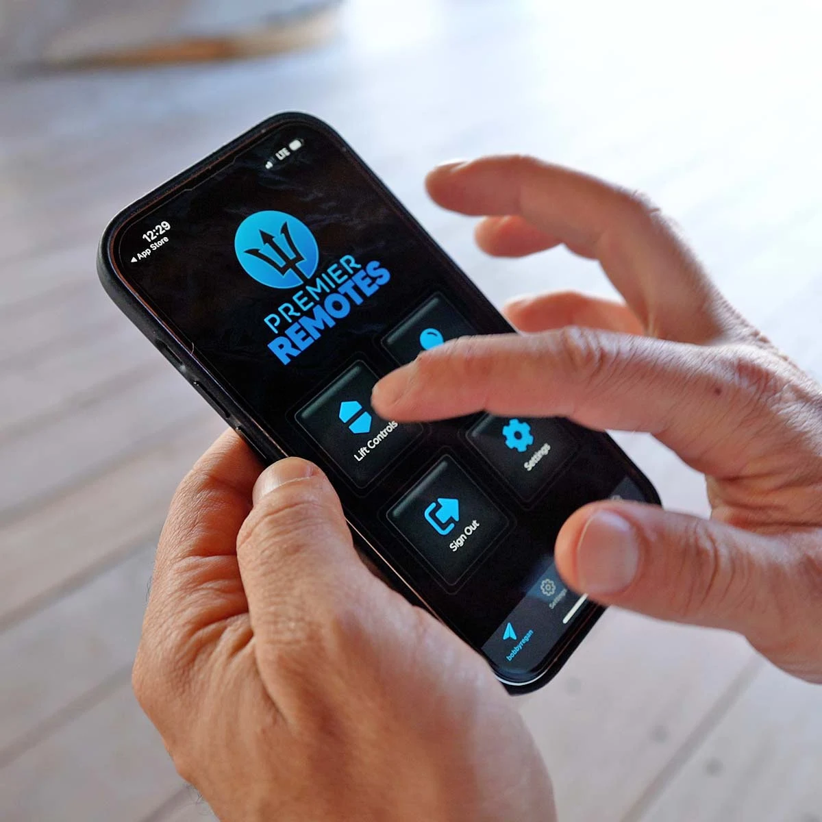 A person using the Premier Remotes app on a phone